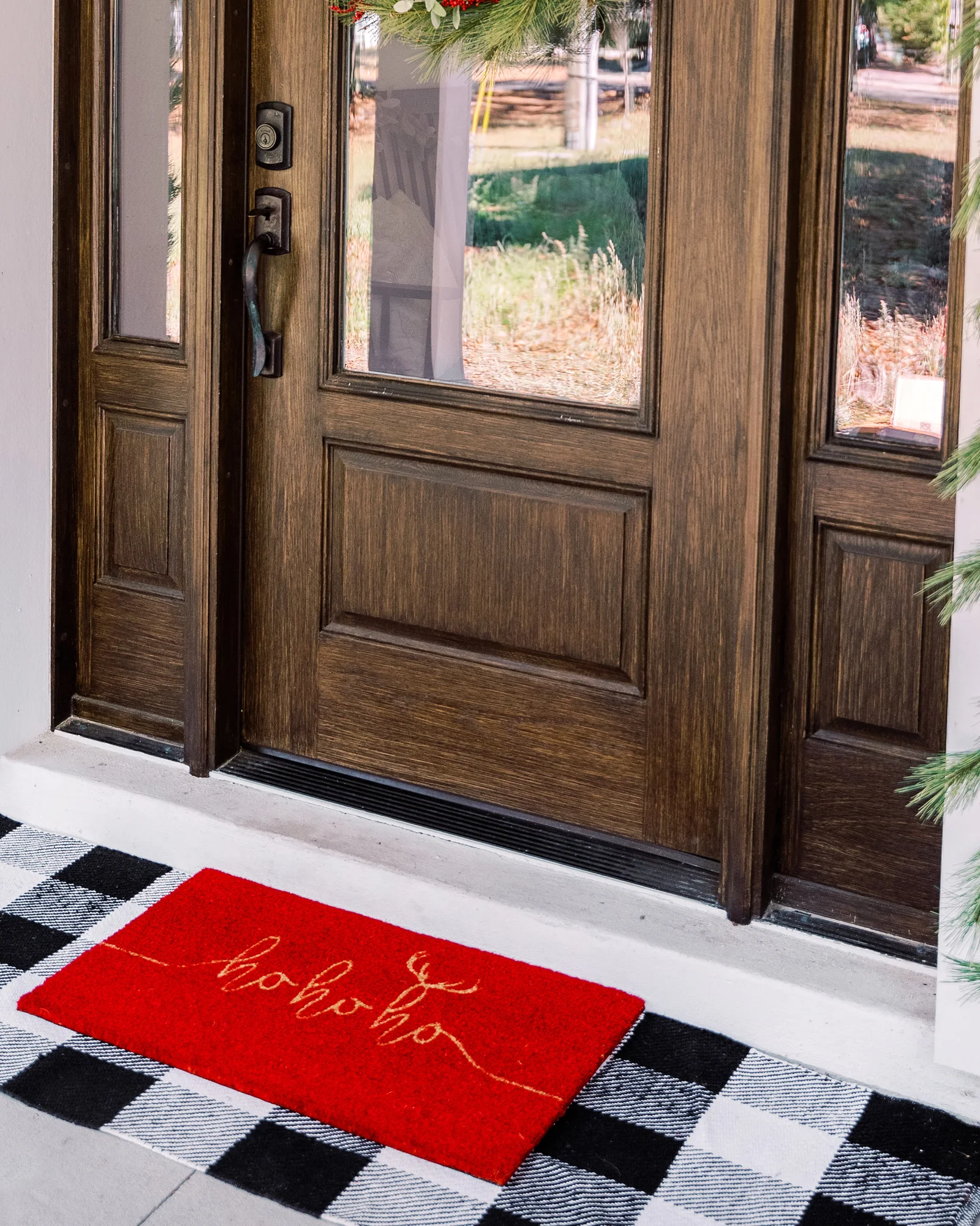 Seasonal line — the holiday mat at a garlanded door